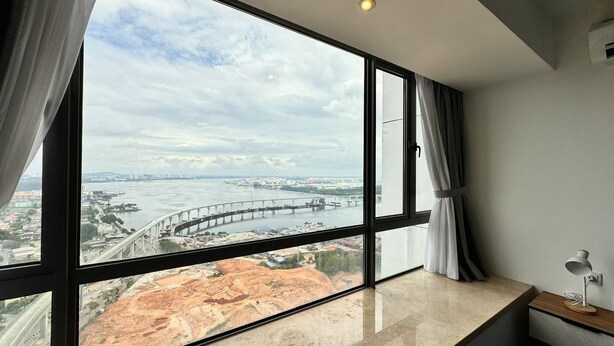 Ein Zimmer mit großem Fenster und Blick auf eine Brücke und einen Fluss.