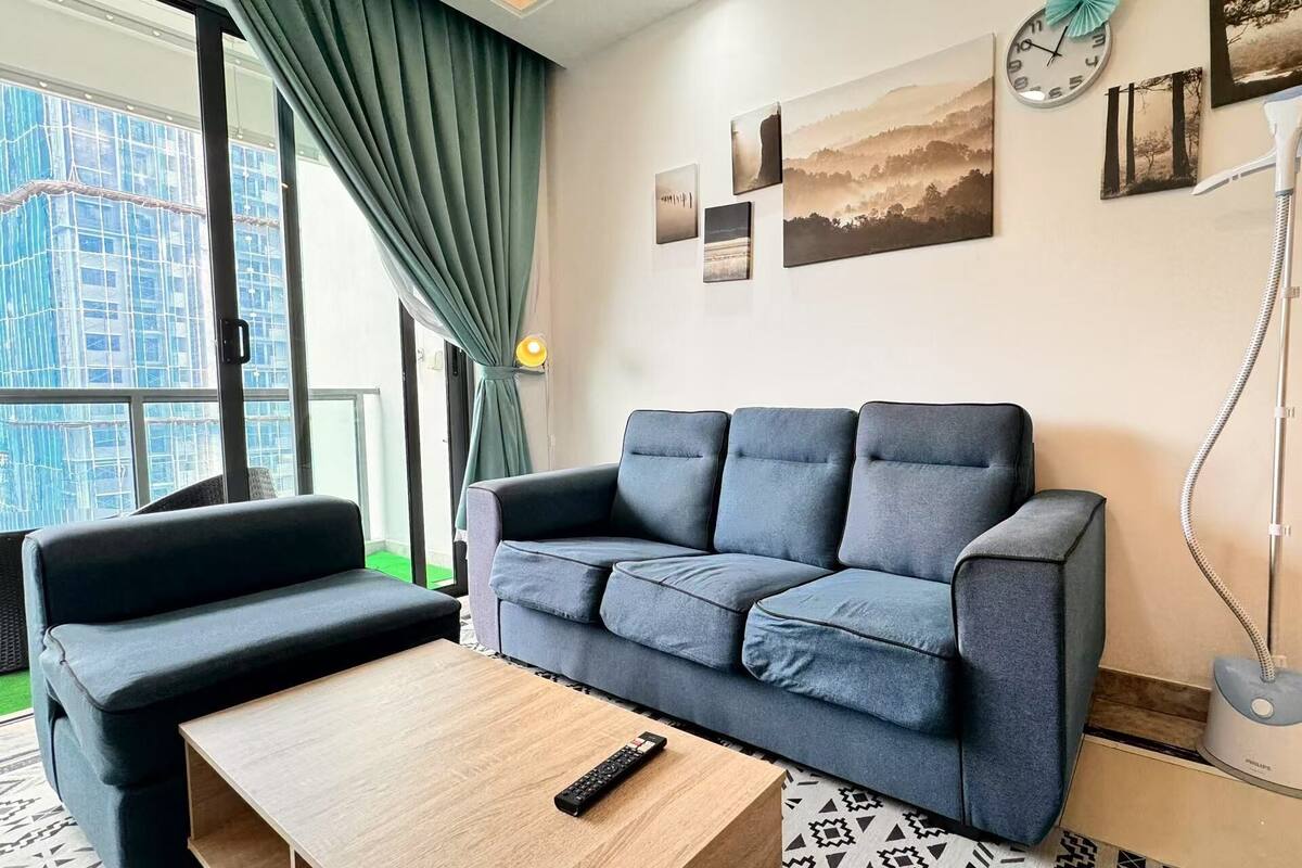 A modern living room with a grey sofa, a wooden coffee table, and a remote control on it.