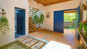 Un interior espaiós amb una escala de fusta, una planta en test i vista a l'exterior.