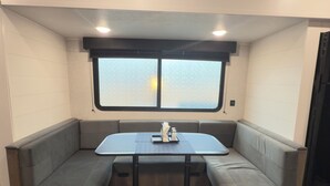 A compact, modern kitchenette with a built-in stove, a sink, and a countertop. - Cozy RV Retreat with Private Hot Tub and Fenced Yard (Spring Hill)