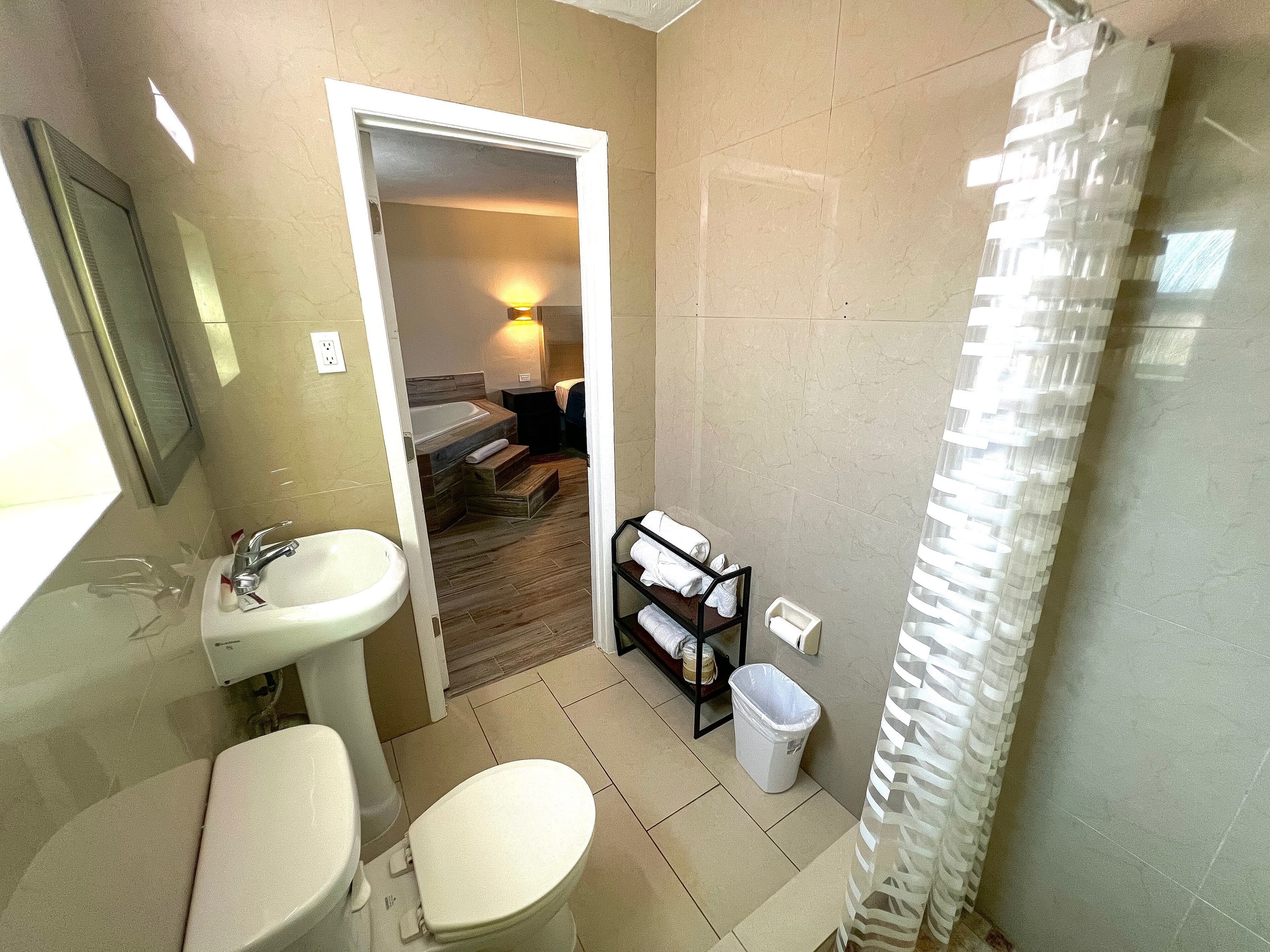 A bathroom with a sink, toilet, and shower curtain.