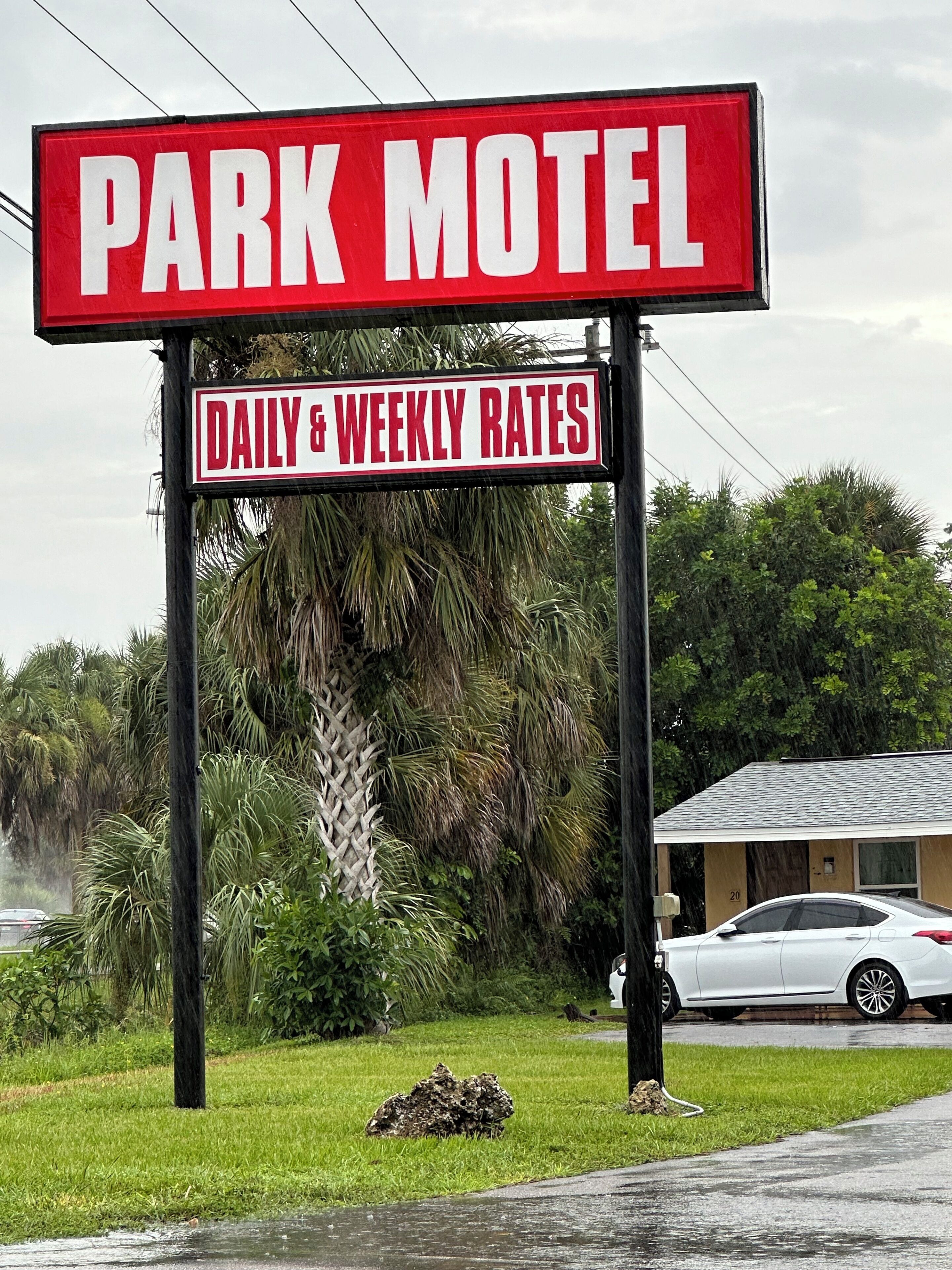 Une enseigne de motel sur laquelle on peut lire « PARK MOTEL » et « TARIFS JOURNALIERS ET HEBDOMADAIRES ».