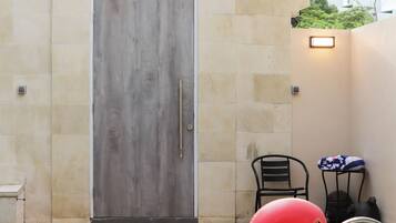 A swimming pool with a pink flamingo float, a door, and a small table with a chair.