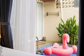 A pool area with a pink flamingo float and a stone sculpture. - Otia Villa by Premier Hospitality Asia (Nusa Dua)