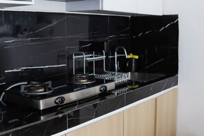 Eine Küche mit schwarzem Marmor-Arbeitsplatz, Edelstahlgeräten und Holzschränken.