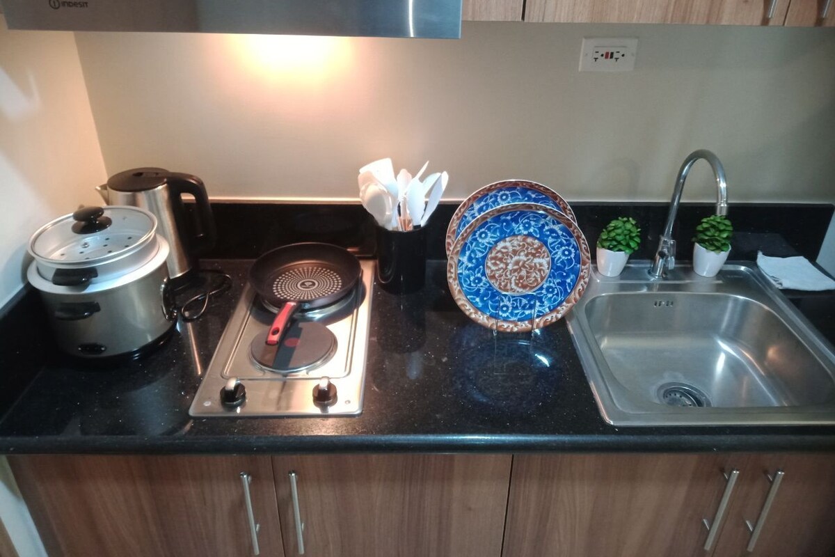 Una cocina con estufa, pileta y muebles de madera.