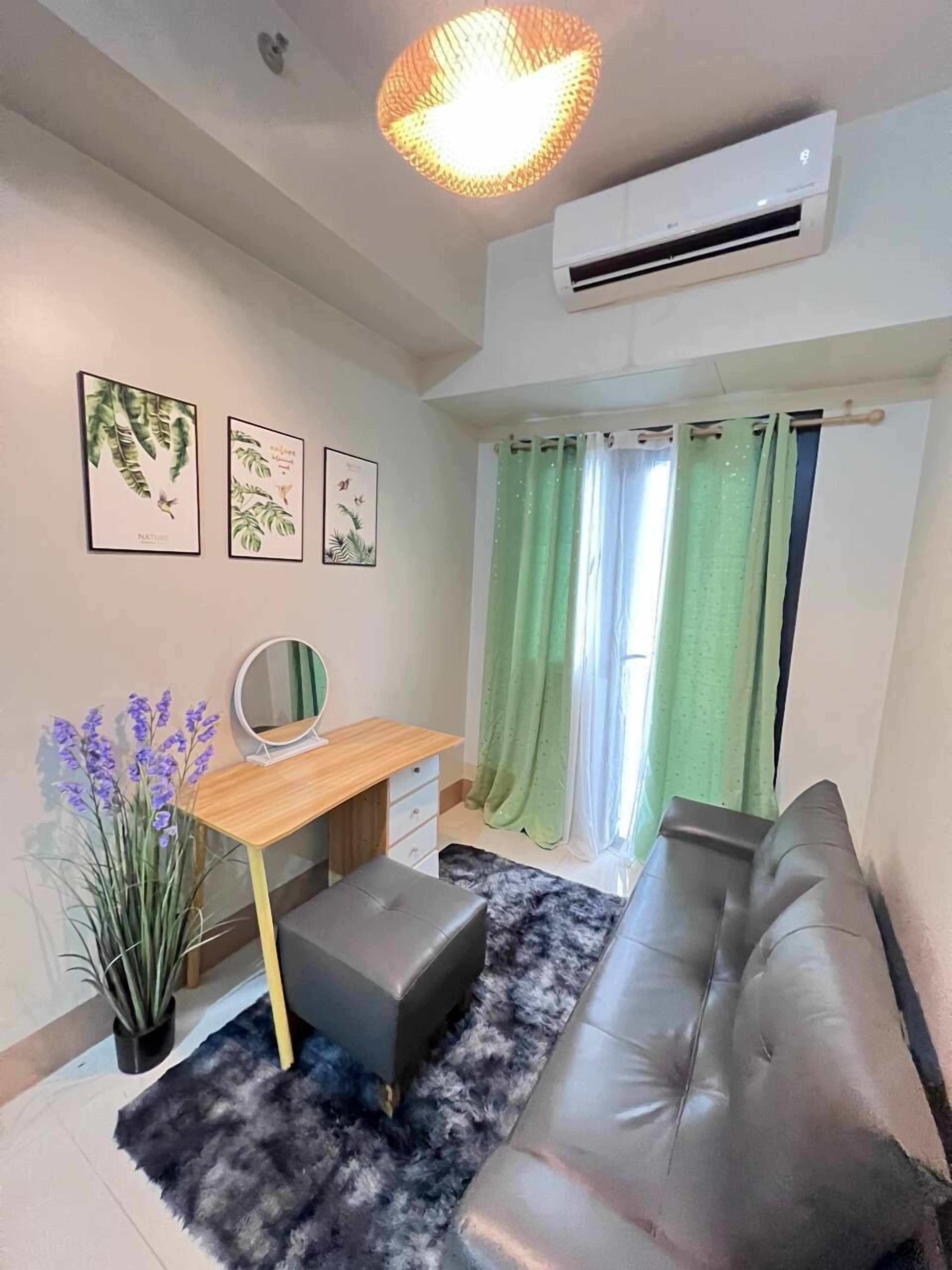 Una sala moderna con un sofá, un escritorio, un espejo y una planta en maceta.