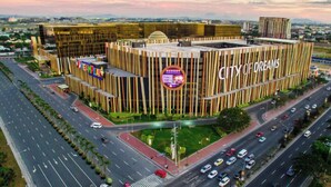 A modern building with the sign "City of Dreams" and a large circular logo.