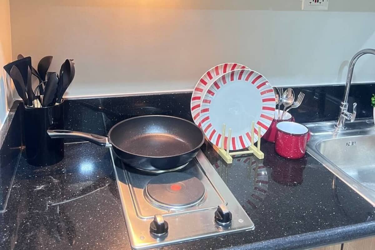 Une cuisine équipée d’une cuisinière, d’un évier et de meubles de rangement en bois.