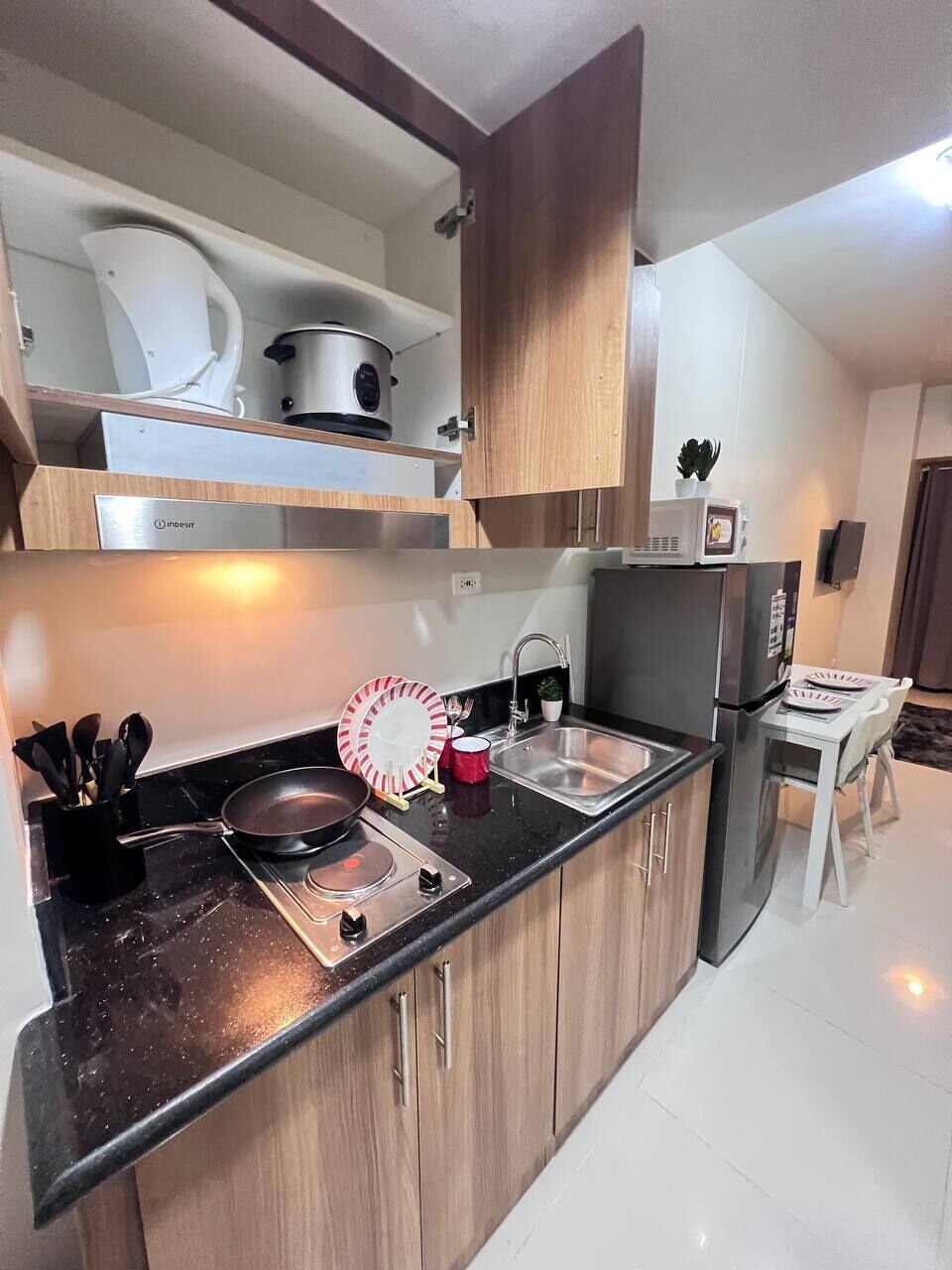 Una cocina moderna con estufa, fregadero y microondas.