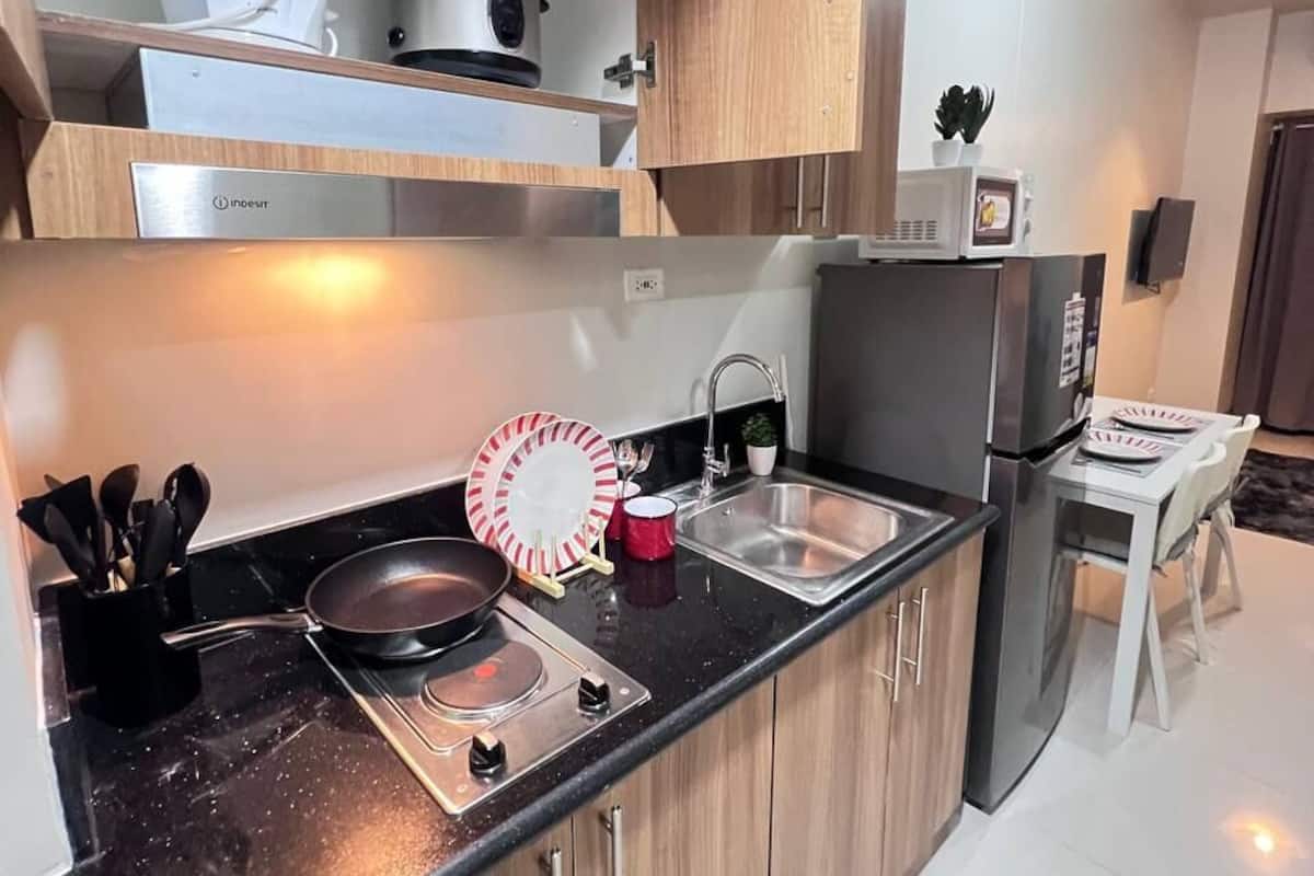 Una cocina moderna con estufa, fregadero y microondas.