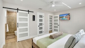 Ein modernes Schlafzimmer mit einem Bett, einem großen Fenster und einem Bild von einem Schwimmbad.