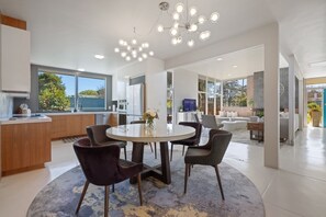 Enjoy meals around the central dining table in this open-plan living space with a kitchen.