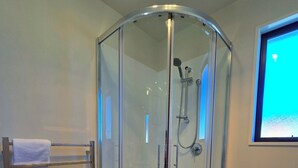 A glass-enclosed shower with a handheld showerhead and a handheld faucet. - Kingfisher Lodge Studio (Lake Tekapo)