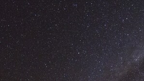 A house with a wooden exterior and a brick foundation, under a starry night sky. - Hunter studio room-Twin (Lake Tekapo)