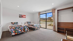 A bedroom with two beds, a large window, and a view of the outdoors. - Hunter studio room-Twin (Lake Tekapo)