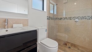 A modern bathroom with a glass-enclosed shower, a white sink, and a toilet. - Hunter studio room-Twin (Lake Tekapo)