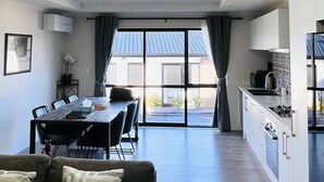 Een moderne leefruimte met dakraam, een eethoek en een keuken.
