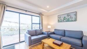 Una sala de estar moderna con un conjunto de sofás, una mesa de centro y un cuadro en la pared.
