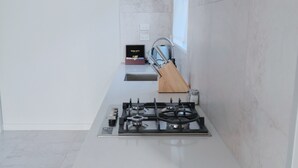 A modern kitchen with a gas stove, a wooden cutting board, and a stainless steel range hood. - Starry Heaven 2bdr2ba (Lake Tekapo)