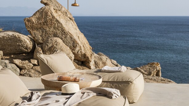 A sun lounger with a view of the sea, a large rock, and a lamp. - Luxury 5BDR Retreat in Mykonos (Mikonos)