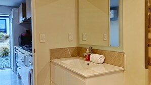 Une salle de bain moderne avec un grand lavabo, un miroir et une serviette.