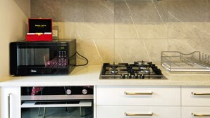 Une cuisine moderne dotée de meubles en bois, d’une cuisinière en acier inoxydable, d’un four à micro-ondes et d’un four traditionnel.
