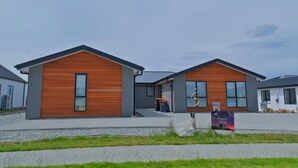 Ein modernes, zweistöckiges Gebäude mit Holzfassade und großen Fenstern.
