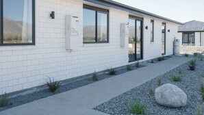 En moderne bygning med en facade af lyse mursten, store vinduer og en sti til indgangen.
