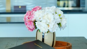 A table with a book and a vase of flowers. - Stargazing Tekapo Apartment C (Lake Tekapo)