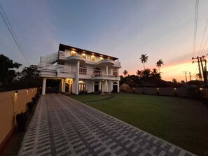 A two-story building with a central courtyard, surrounded by a low wall and a pathway leading to the entrance. - De centrum Hotel - Negombo (Negombo)