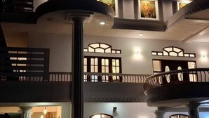 Un edifici de diversos pisos amb balcons, grans finestres i una columneta central.