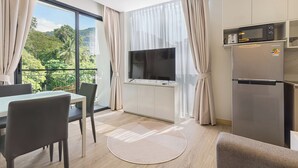 Una cocina moderna con televisor integrado, refrigerador y comedor con mesa y sillas.