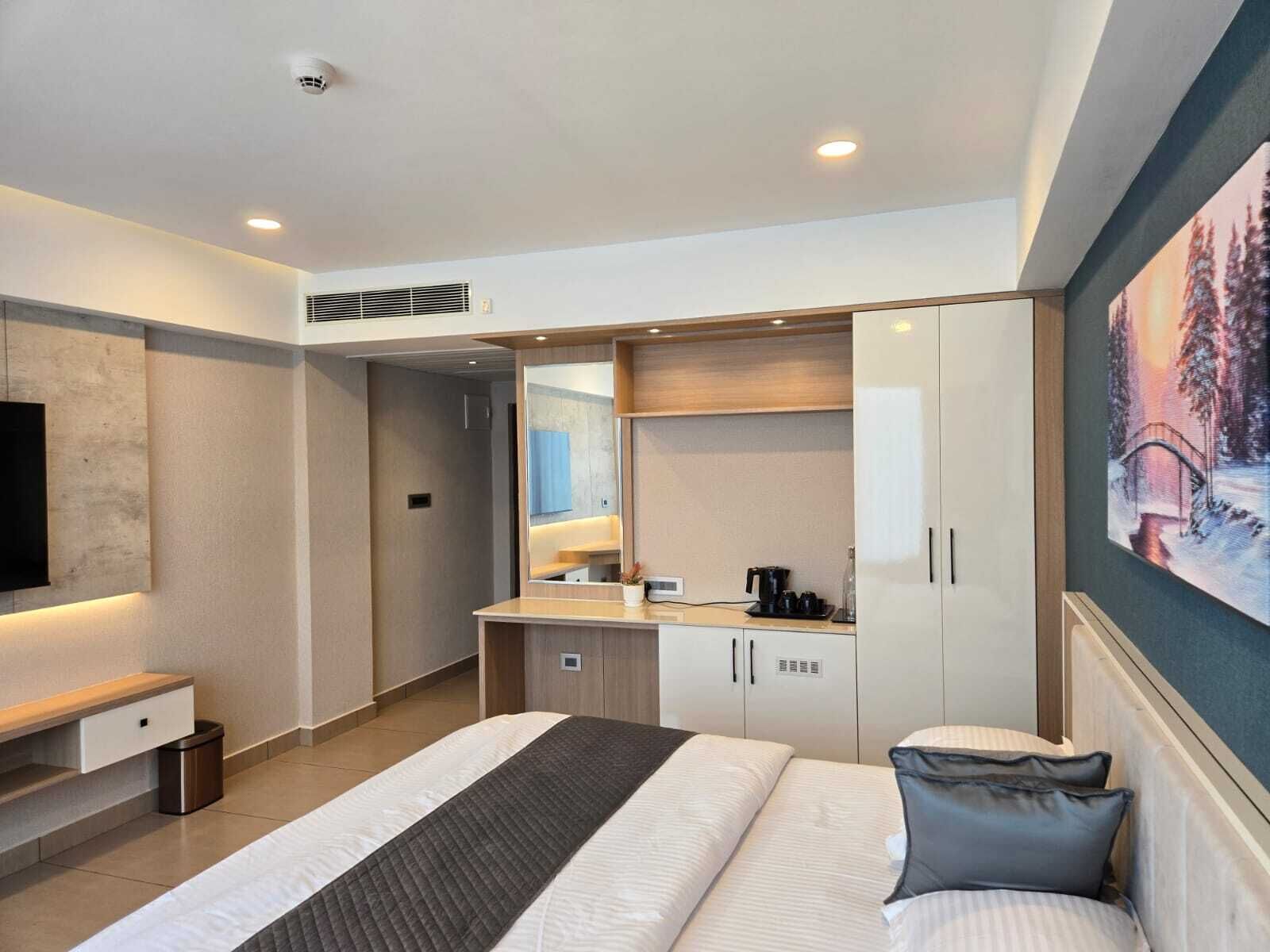 Une chambre d’hôtel moderne, dotée d’un grand lit, d’un bureau et d’une télévision.