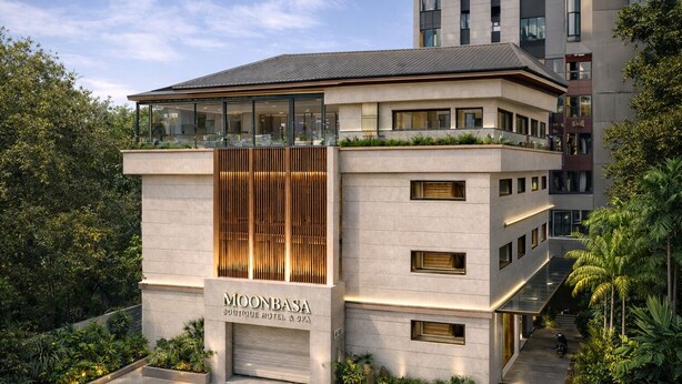 A modern boutique hotel with a prominent entrance, large windows, and a rooftop terrace.