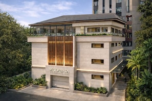 Ein modernes Boutique-Hotel mit markantem Eingang, großen Fenstern und einer Dachterrasse.