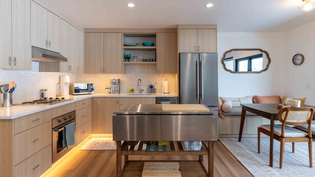 A modern kitchen with wooden cabinets, stainless steel appliances, and a central island.