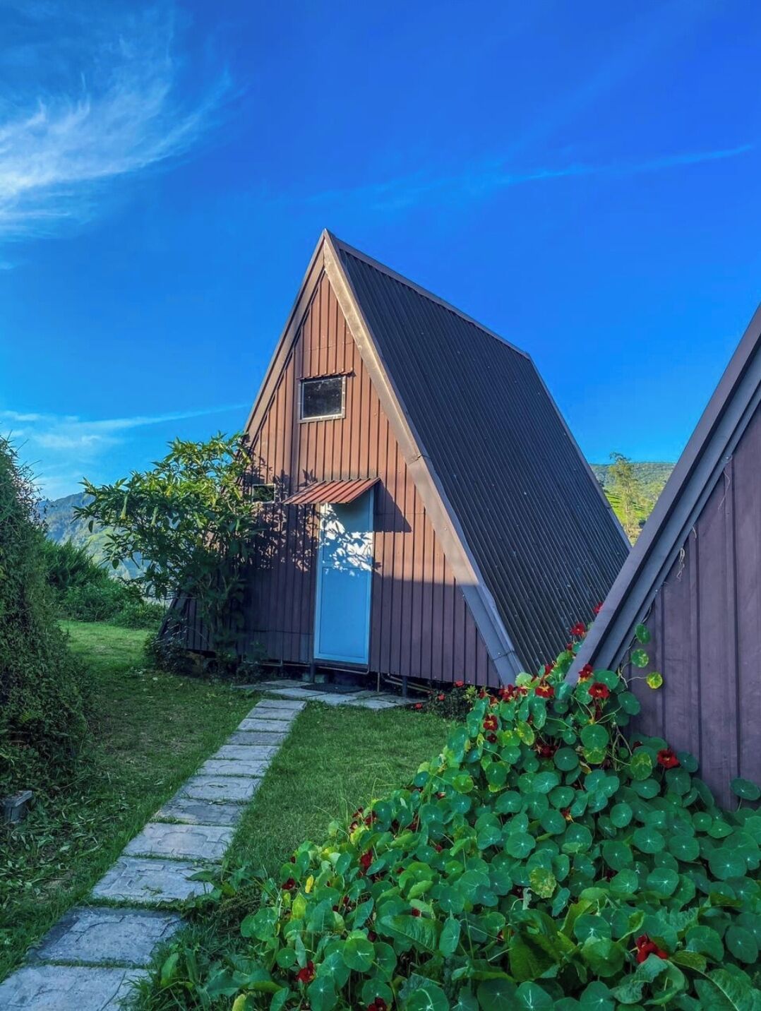Un bâtiment de style rustique, semblable à une grange, avec un toit en pente, une petite fenêtre et une porte.