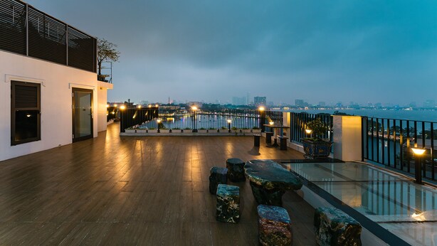 A rooftop terrace with a view of the city skyline and a body of water. - An Nguyen Lakeside Residence (Hanoi)