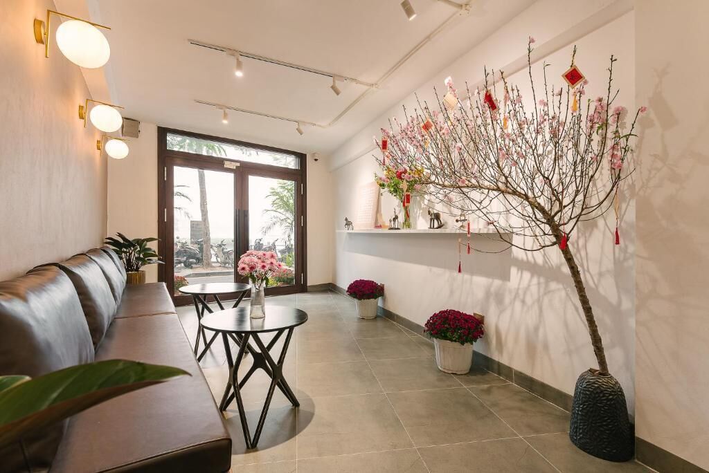 Un interior moderno con un sofá, mesas redondas y plantas en macetas.