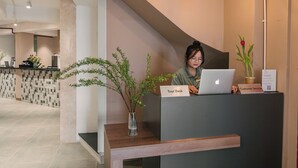 A reception desk with a laptop, a vase with branches, and a sign reading "Tour Desk". - An Nguyen Lakeside Residence (Hanoi)