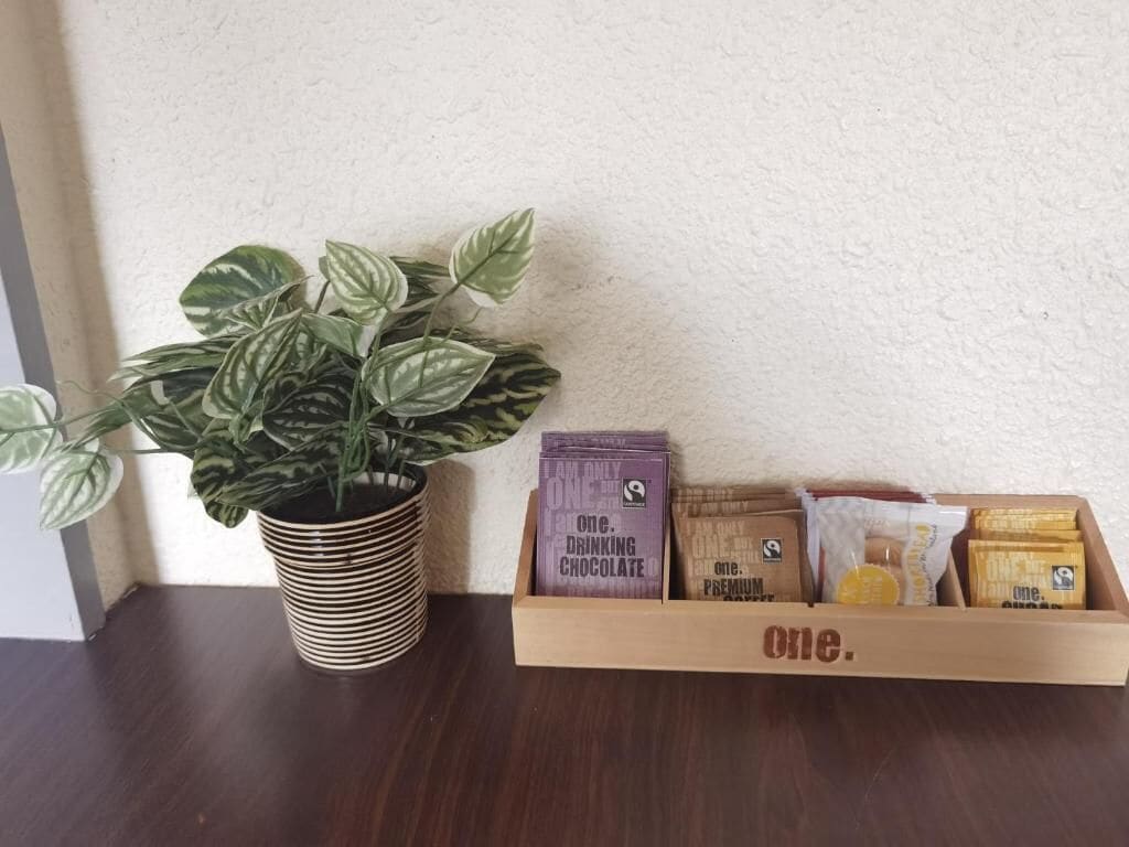 Een bloempot met een plant en een houten doos met chocoladerepen op een tafel.