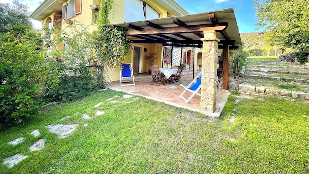 A yellow house with a covered patio, stone steps, and a garden. - " Villa Teresa con patio " (Bari Sardo)