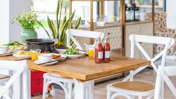 A dining table with various dishes, a hot pot, and bottles of ketchup.