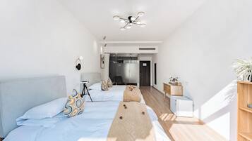 Una habitación de hotel moderna con una cama grande, un escritorio y una lámpara colgante.