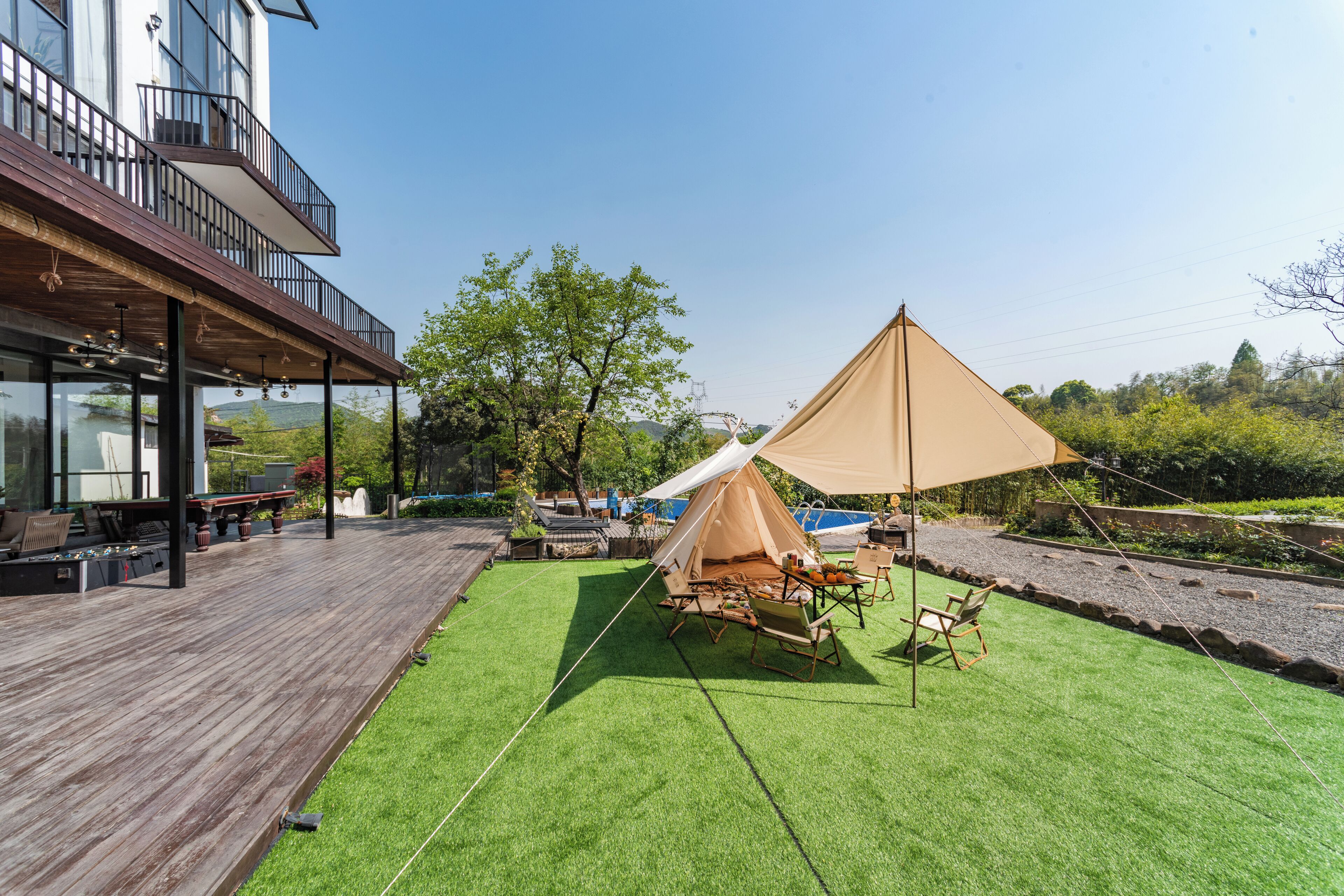 A wooden deck with a tent and outdoor furniture.