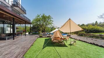 A wooden deck with a tent and outdoor furniture.
