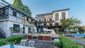 A modern building with a pool, outdoor seating, and a well-maintained garden.