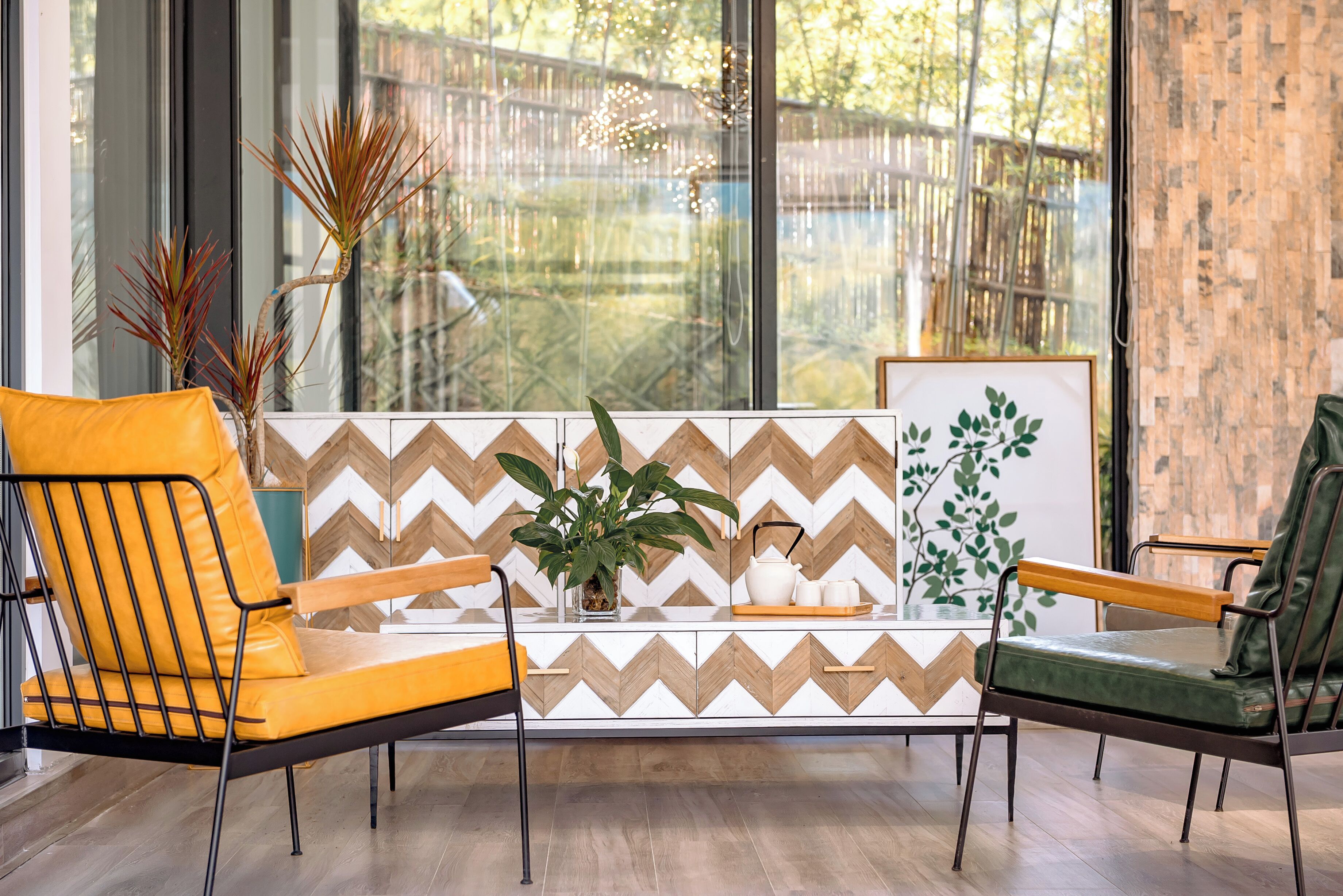 Una sala moderna con dos sillones, una mesa de centro y un detalle decorativo en la pared.