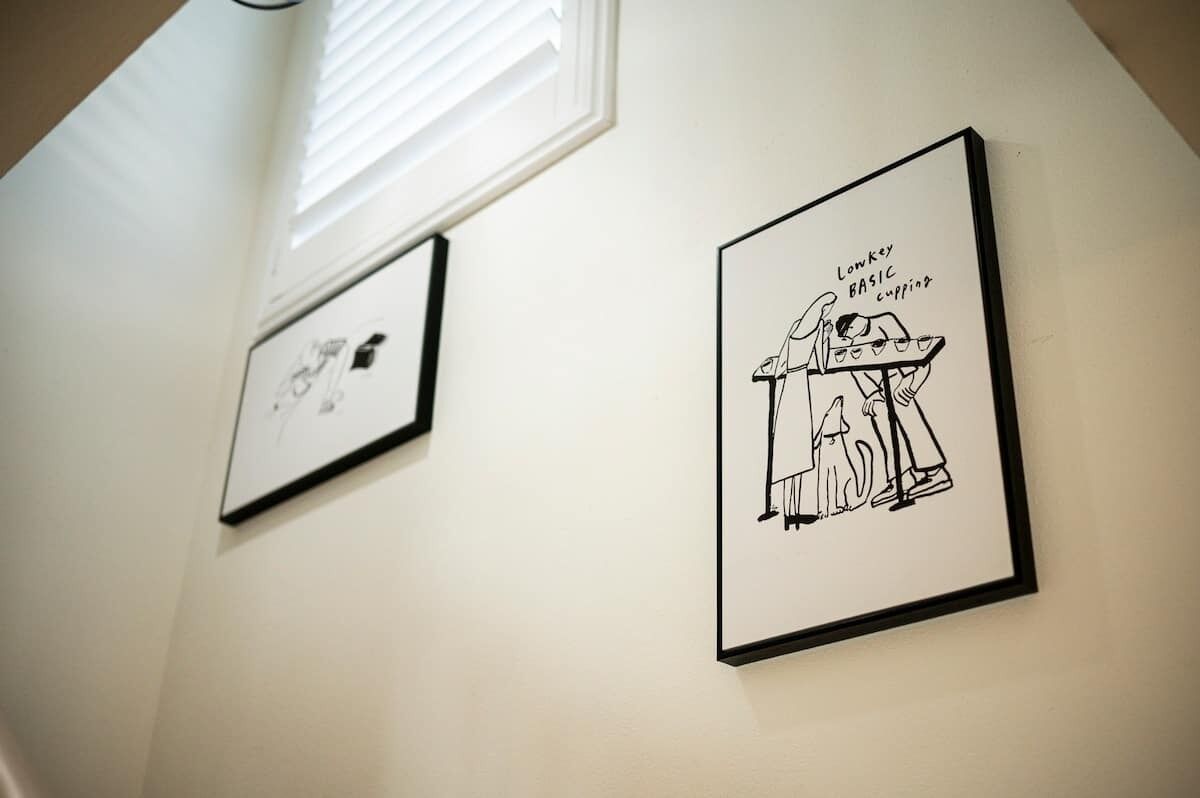 Twee ingelijste zwart-wit tekeningen aan een muur.